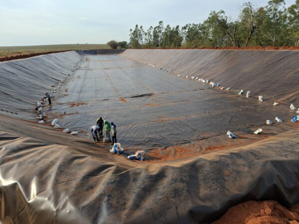 Equipe da SEAGRO instalando geomembrana PEAD em lagoa